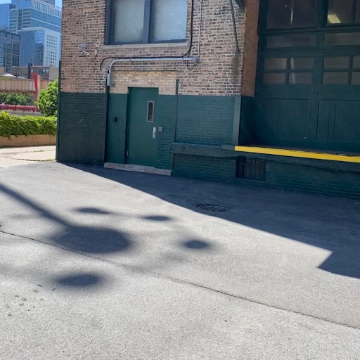 Clean, swept commercial loading dock and green service entrance at a downtown Chicago property maintained by Snow Pushers portering crews